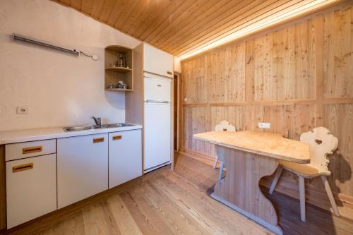 a kitchen with wooden walls and a wooden table at Untervernatsch Fewo Ötzi in Senales