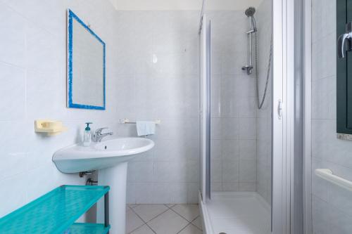 a white bathroom with a sink and a shower at Casa Vacanza Casi 2 in Villasimius