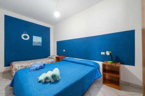 a blue bedroom with two towels on a bed at Casa Vacanza Casi 2 in Villasimius