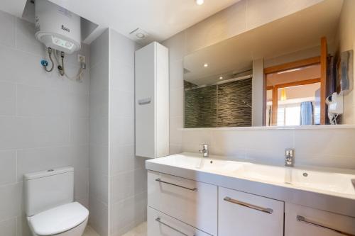 a bathroom with a toilet and a sink and a mirror at Apartamento Trilo 24 in Es Pujols