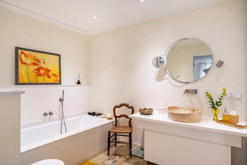 a bathroom with a tub and a sink and a mirror at Architektenhaus Baden mit Studio in Weier
