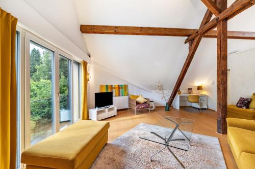 a living room with large windows and a couch at Architektenhaus Baden mit Studio in Weier