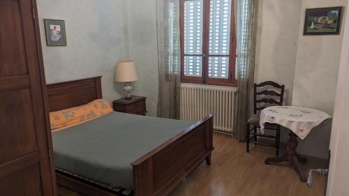 a bedroom with a bed and a table and a chair at Appartement rochenoir in Saint-Jean-de-Maurienne