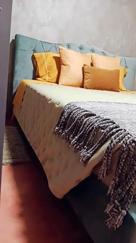 a bed with yellow and brown pillows on it at Ká T'Espero in Penha Garcia