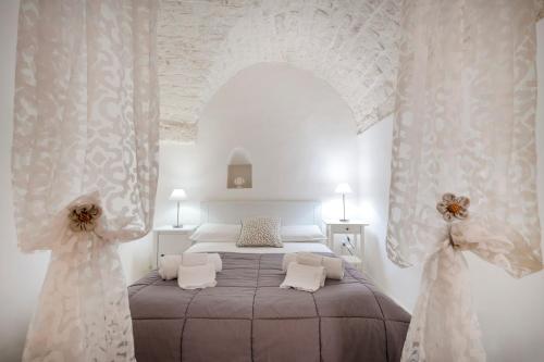 a bedroom with a bed in a room with curtains at Casa Pà in Ostuni