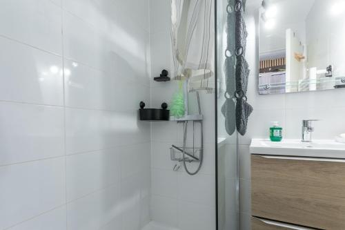 a white bathroom with a shower and a sink at Appartement Cap Esterel - piscine in Saint-Raphaël