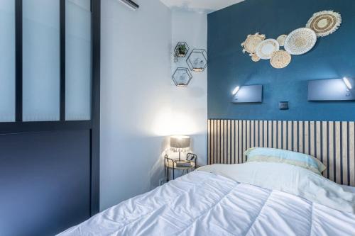 a bedroom with a bed and a blue wall at Appartement Cap Esterel - piscine in Saint-Raphaël