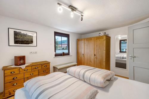 a bedroom with two beds and a dresser at Ferienwohnung im Salzgässle in Schonach