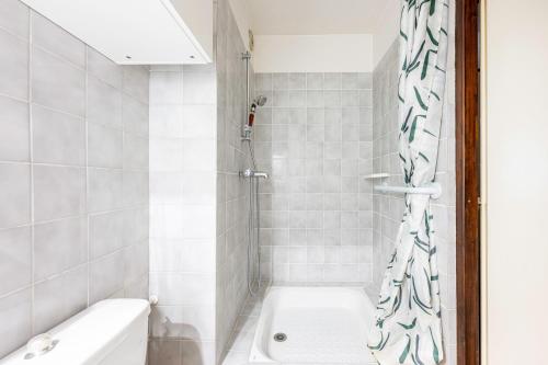 a bathroom with a shower and a tub and a sink at Les cybeles - studio 3 personnes in Brides-les-Bains