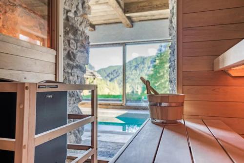 a room with a table and a view of a pool at Dolomites Luxe Cesa Del Louf in Arabba