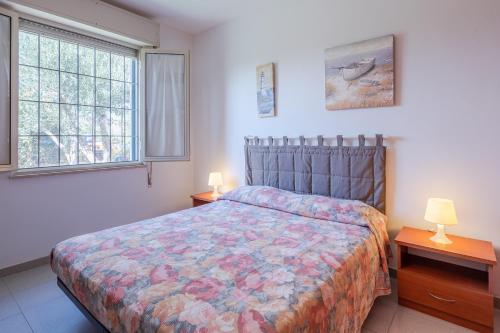 a bedroom with a bed and two lamps and two windows at Villa Amore - San Lorenzo in Reitani