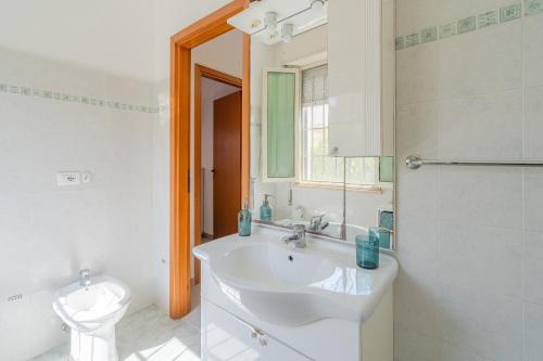 a white bathroom with a sink and a toilet at Villa Amore - San Lorenzo in Reitani