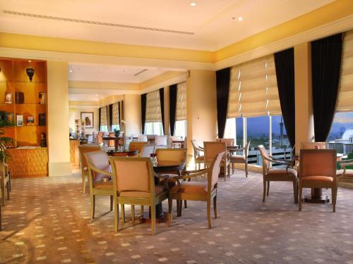 a dining room with tables and chairs in a building at Hotel Borobudur Jakarta in Jakarta