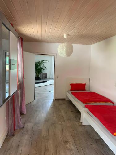 a bedroom with a large bed with a red blanket at Lieblingsplatz in Weiler-Simmerberg