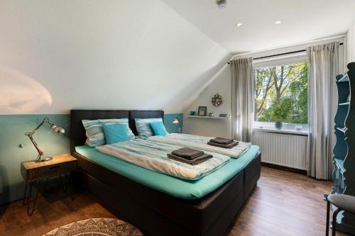 a bedroom with a bed with blue sheets and a window at Ferienhaus Ankerglück in Lensahn
