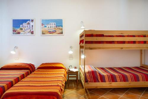 a bedroom with two bunk beds and a desk at Trilo Dalia in Marina di Grosseto