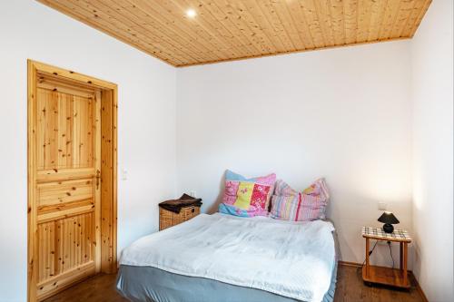 a bedroom with a bed and a wooden ceiling at Moderner Bungalow, rollstuhlgerecht in Warnow