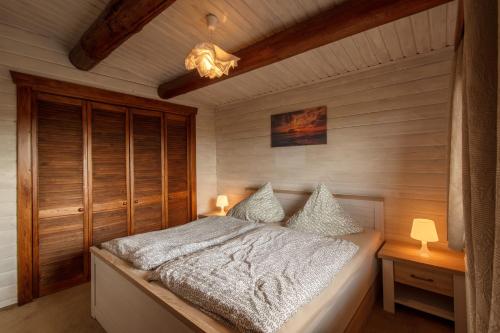 a bedroom with a bed with white sheets and pillows at Gemütliches Blockhaus im Harz in Bad Sachsa