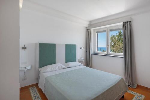 a bedroom with a large bed and a window at Suite Tramonto in dependance in Conca dei Marini