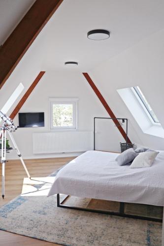 a white bedroom with a bed in a attic at Hq16 - Modernes Ferienhaus in Neuenburg am Rhein
