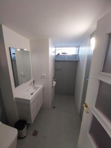 a white bathroom with a sink and a mirror at I Have A Dream in Agia Pelagia