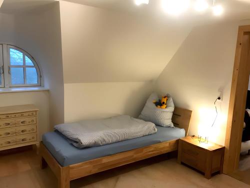 a small bed in a room with a window at Ferienhaus Osterdeich in Neukirchen