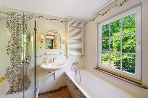 a bathroom with a tub and a sink and a window at Im grünen Winkel in Brüggen