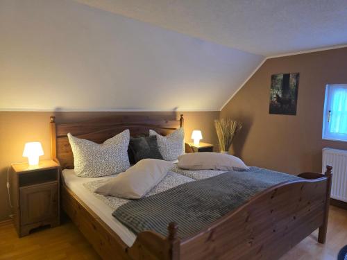 a bedroom with a large wooden bed with pillows at Huthaus zum Molchner Stollen in Pobershau
