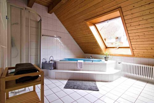 a large bathroom with a tub and a window at Kempfenhof in Seelbach