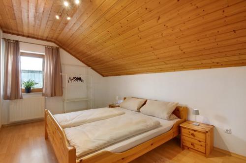 a bedroom with a large bed with a wooden ceiling at Ferienhäusl in Eschlkam