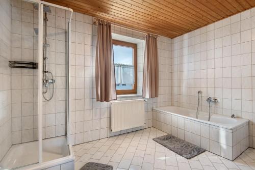 a bathroom with a shower and a tub and a sink at Ferienhäusl in Eschlkam