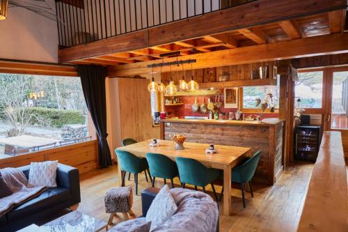 a kitchen and dining room with a wooden table and chairs at Chalet Du Houx in Les Allues