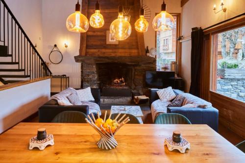a living room with a table and a fireplace at Chalet Du Houx in Les Allues