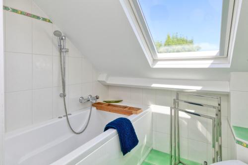 a bathroom with a shower and a bath tub with a window at Maison Ker Hélène sur grand jardin in Guérande