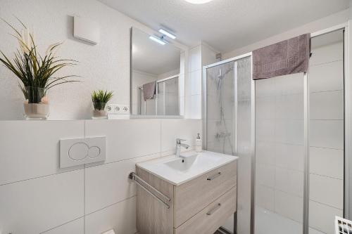 a white bathroom with a sink and a shower at Ferienwohnung Morgensonne in Wolfach