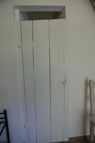a white cabinet in the corner of a room at Kate unter Reet im Grünen in Buchholz