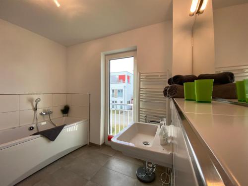 a bathroom with a sink and a bath tub at Lootsen Hus by Seeblick Ferien in Olpenitz