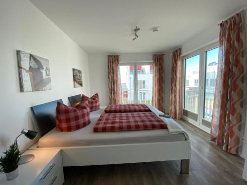 a bedroom with a large bed with red pillows at Lootsen Hus by Seeblick Ferien in Olpenitz