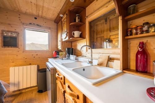 a kitchen with a large sink and wooden walls at Le Chalet Jarrier in Jarrier