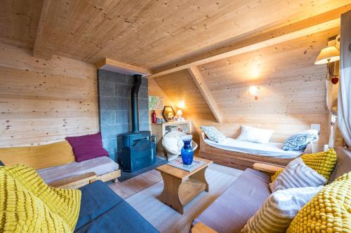 a living room with a couch and a stove at Le Chalet Jarrier in Jarrier