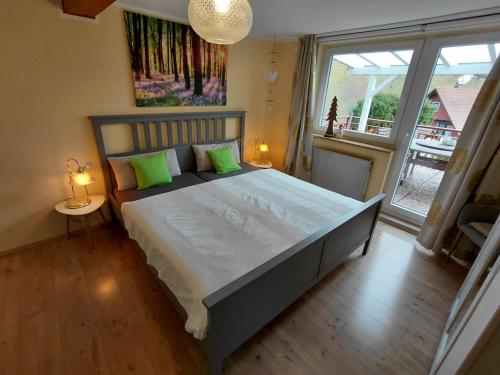 a bedroom with a large bed and a large window at Haus Am Waldrand in Schenkenzell