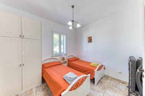 a bedroom with two beds and a window at E case e Leviche in Castrignano del Capo