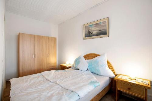 a small bedroom with a bed and two night stands at Ferienwohnung 'Ferien bei Buske' in Tellingstedt
