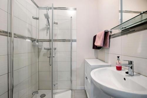 a white bathroom with a sink and a shower at Ferienwohnung 'Ferien bei Buske' in Tellingstedt