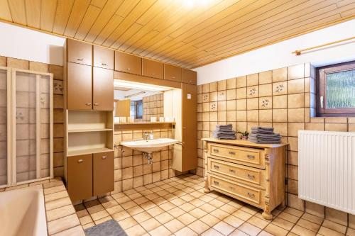 a bathroom with a sink and a tub and a mirror at Haus Waldesruh in Medebach