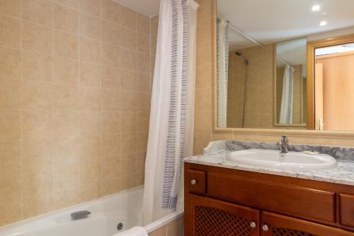 a bathroom with a sink and a tub and a mirror at Guadalmina Baja in Marbella