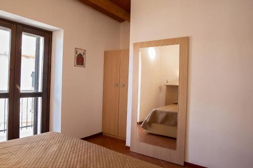 a bedroom with a mirror and a bed in it at Casa Arconides in Motta D'affermo