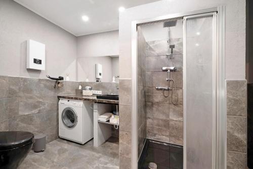 een badkamer met een douche en een wasmachine bij Bellevie in Kell