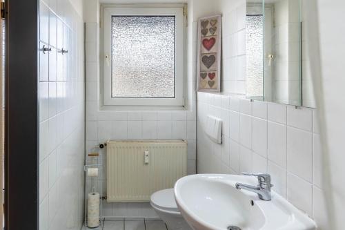 a bathroom with a sink and a toilet and a window at Apartment Magdeburg in Magdeburg