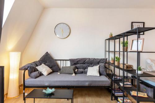 a living room with a couch and a clock on the wall at Apartment Magdeburg in Magdeburg